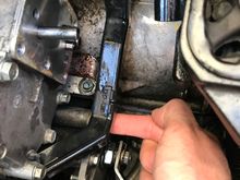 Remove the bolt where my Fwanga’ is and your wiring harness plastic will be free, allowing you access to undo the six bolts of the lower transmission solenoid.