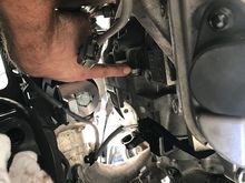 Pointer points at the same bolt in the anterior part of the engine. This bolt goes from engine to tranny.

To get to this bolt you must remove the part of the front mount that goes from the front mount to the engine. There are a total of x5 bolts to remove this bracket.