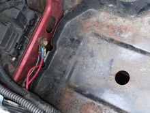 Relocated to the inner fender beside the battery box.