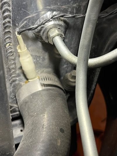 This pic shows the temp probe for the AutoCool fan controller is sandwiched between the radiator hose and the outlet port.