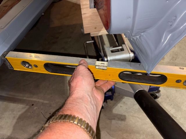 With single top cap screw on top hinge tightened, I jacked up the door until door bottom was level, plus a little for expected Sag, and then tightened bottom hinge screws and rest of top screws.