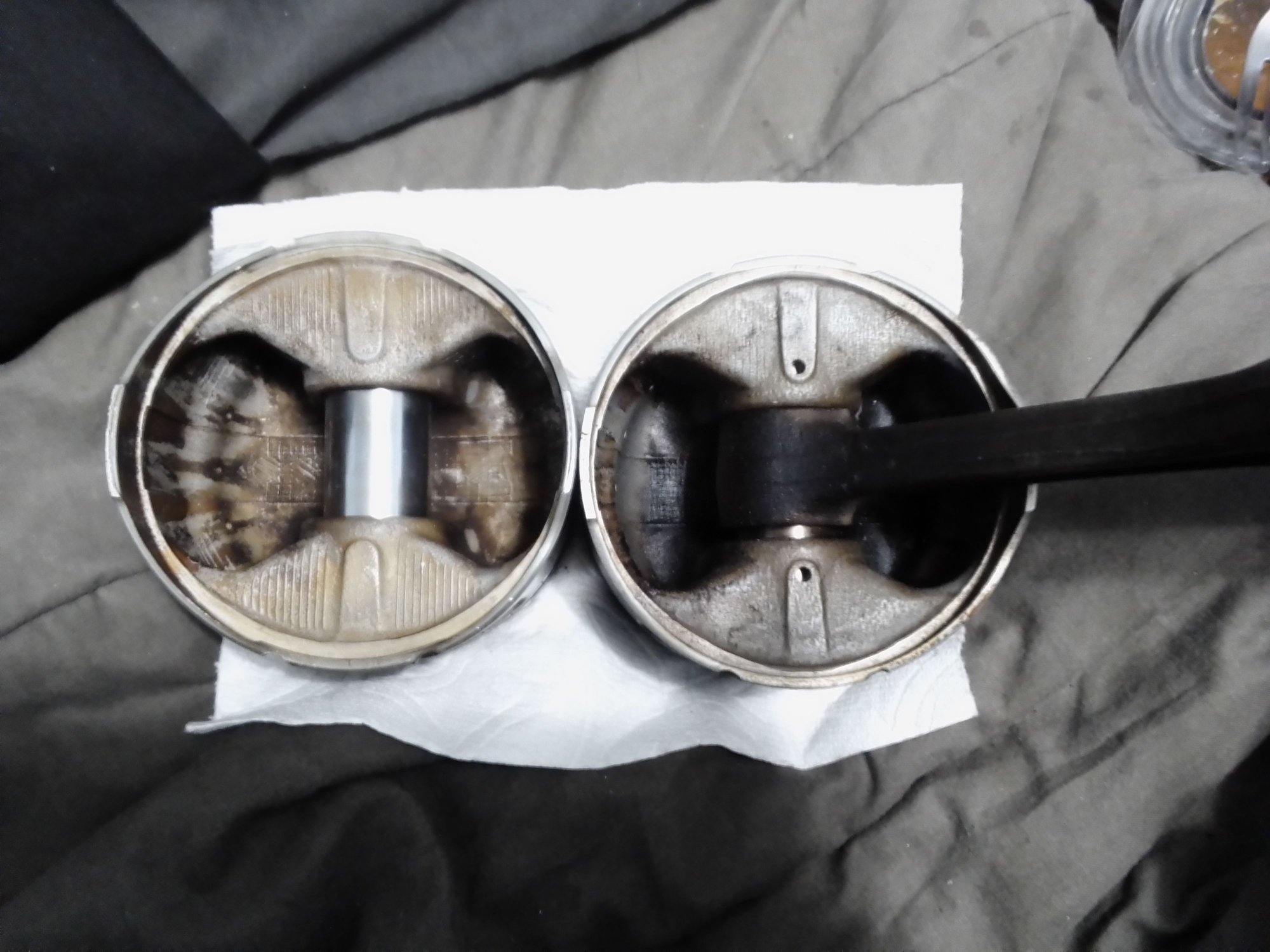 Drilled holes at wristpin area underside of pistons