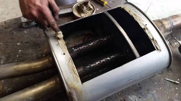 A picture of a Mini Cooper S muffler with the baffling material removed