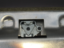 ABOVE - this is the back side.  The right screw holds the mechanism in place.  The left screw holds the metallic triangle piece in place which jams the black U-latch into position.