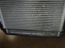 This is driver's side condenser and radiator.  Note the debris build-up on lower right corner of the radiator.  As it gets wet and deteriorates it turns acidic, attacking the radiator.  Cleaning this junk out will prolong component life.