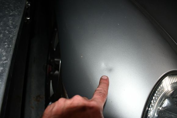 Ding behind passenger headlight.  Young son of former owner knocked over the stock exhaust that was leaning against the wall. (Dad’s fault, obviously!)