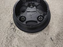 Top view of the mount screwed into the top of the rubber stopper.  You can see the hole drilled through the stopper at about 10 o'clock for the tweeter wires to pass through.