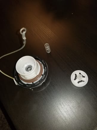 So i had a similar experience today... went to pull the gas cap up from the "cap holder" and it came apart....  the spring and plastic part pictured are all i have.  I think something went down the fuel line though.   Can anyone verify if there is another piece?  I cant find a diagram or similar post anywhere...