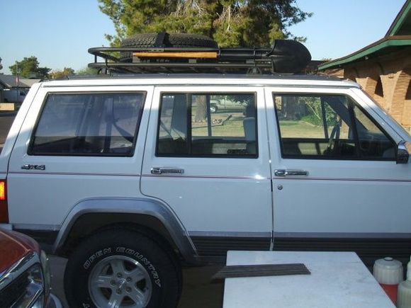 Just a piece of PVC u bolted to the rack. It's a friction fit and just slides in. Tight enough that it won't come loose. Been driving around with it on there for a couple weeks and it's staying put. I've picked up some 1/8" braided steel cable, and used it with a snap swivel to make a safety strap just in case.