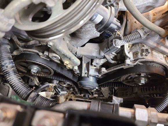 Water pump driven by the timing belt, black pulley at center of image.