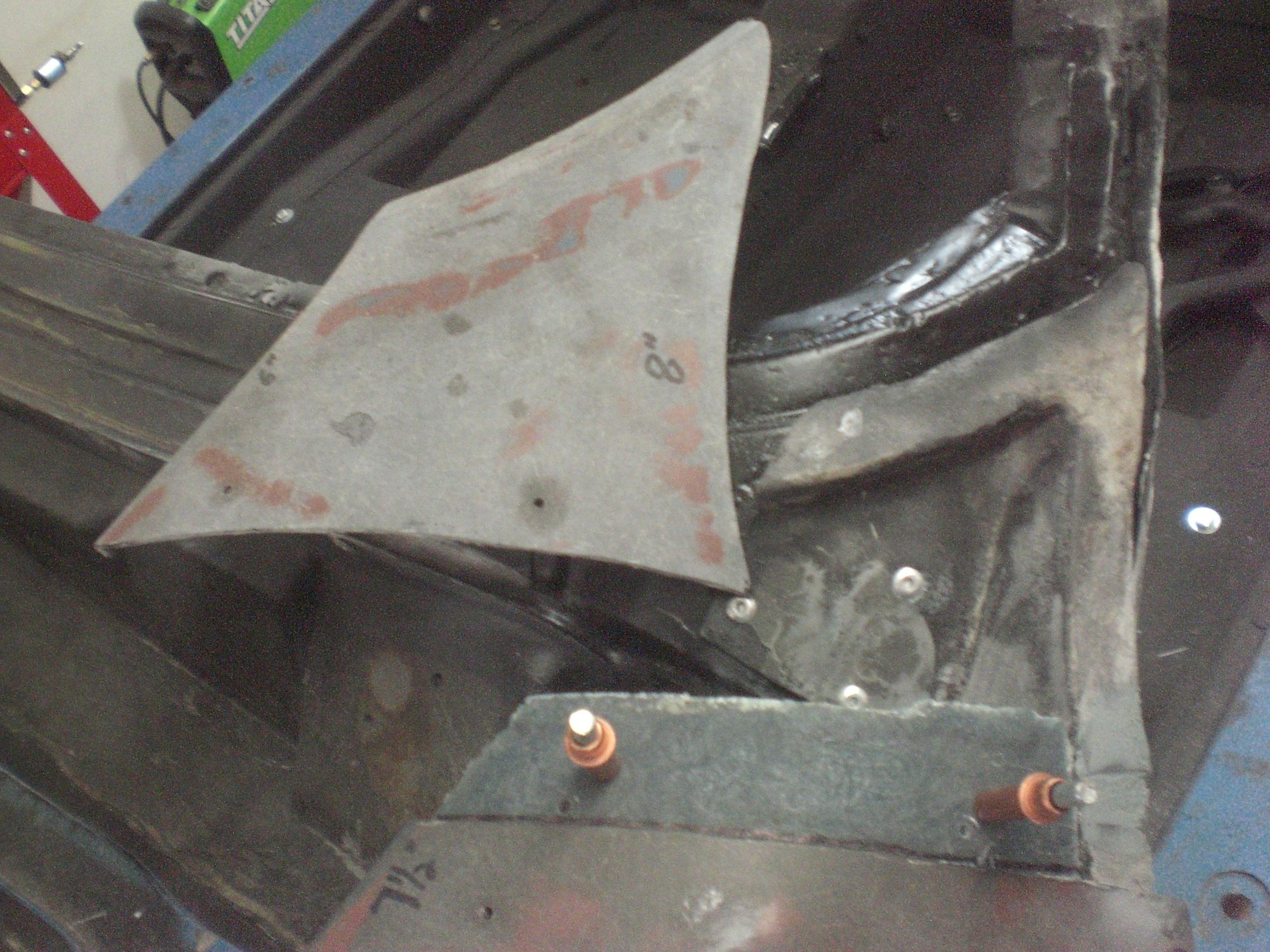 Tip of fender was cut off to allow access to outer lower corner.  After removing inner and outer corners, donor pieces were welded back in.  Then the fender repair was done.  Here the bonding strip is glued to underside of fender waiting for cut tip piece to be reattached.  Cleco pins were used to ensure proper positioning.