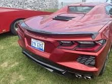 Low rise spoiler ordered with C8 also wraps around above the taillight.  But can be ordered in body color or carbon flash metallic.