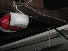 Opener is attached to the beam above the middle of the door.