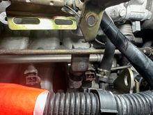 Right bolt securing fuel rail hidden behind bracket
