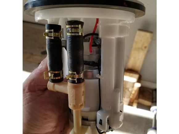 Notice the worm clamp up inside around the plastic housing that the pump nozzle fits into.  Remember to heatshrink the pump nozzle below the barb a couple of times, so the factory grommet is as thick as possible and tightly fits into the housing.  Then tighten the 3/4 inch clamp down slowly and not to tight as to crack the hanger.