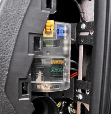 Auxiliary fuse panel behind passenger side dash.