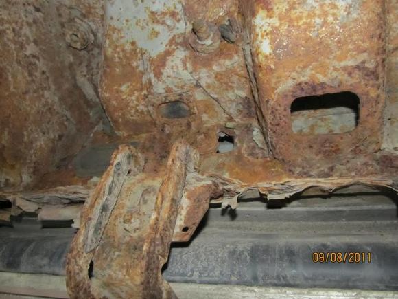 Third from front picture showing cab bottom and running board hangars. This part seems pretty solid, except for the obvious rocker panel repair.
