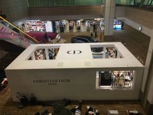 Here’s a shot from outside the lounge.  You see the Christian Dior store in the middle of the terminal and a car display behind it.  The escalator to the lounge is behind the car and store. 