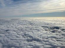Above the clouds at Flight Level 60 (around 6000 feet), heading  198 degrees with a ground speed of 220 knots.
