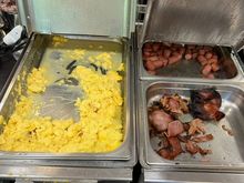 Burnt scrambled eggs and bacon at the breakfast.