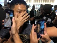 One of the Chinese Police caught by the protestors, he also has long wooden sticks in his bag