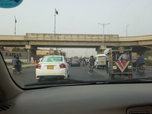 On the way to the Airport. Pakistani Independence Day had just passed (14th Aug), hence national fervor was at it's height. There are 3 flags in this image, can you spot them?
