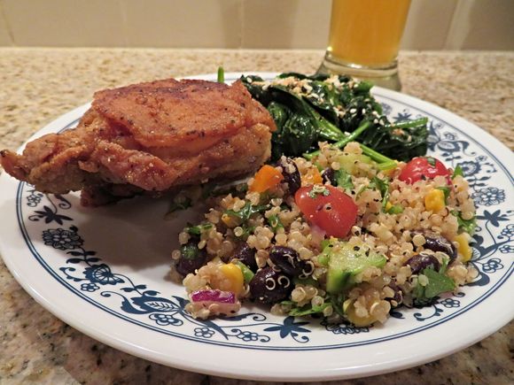 Fried chicken thigh, quinoa salad, sauteed spinach.