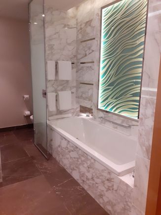 Bath with lighted mirror. Toilet behind smoked glass door. Shower ( walk in with rain head) in separate door beside toilet. Sink to the left ( incl mirror with built in small tv- tv did not work on my stay- minor point)