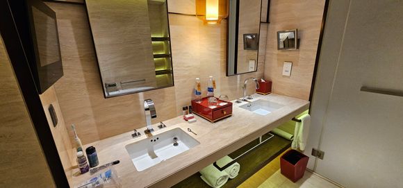 Twin sinks with some toiletries.  
Red box has some bits and pieces in it.