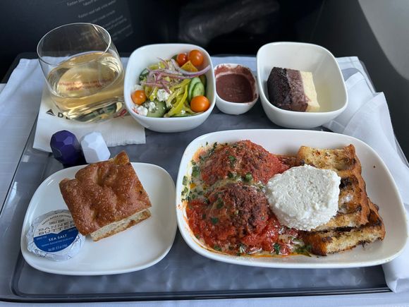 Delta One meal - ginger ale, mixed salad, mousse cake, meatballs, and focaccia bread

