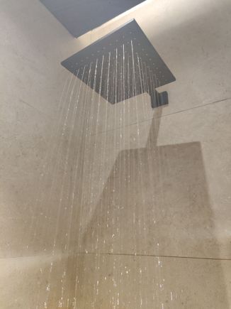 Water pressure is low but ok for the rain shower. Gravity helps.