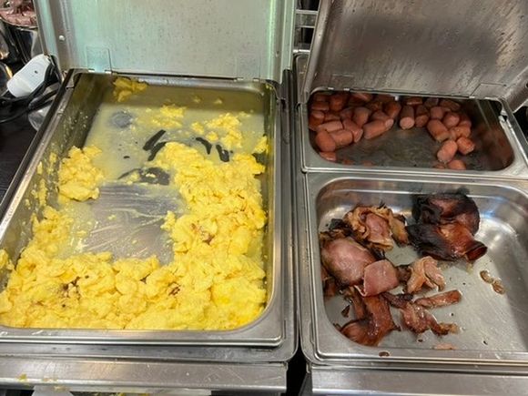 Burnt scrambled eggs and bacon at the breakfast.