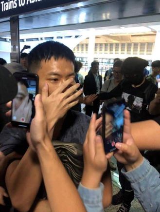 One of the Chinese Police caught by the protestors, he also has long wooden sticks in his bag