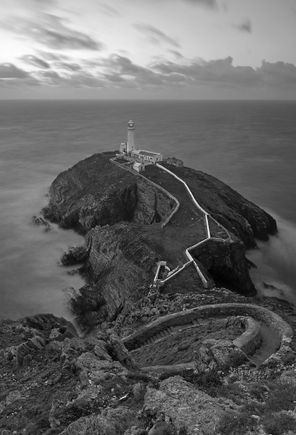 Goleudy Ynys Lawd (South Stack Lighthouse) on the northwestern coast of Wales.  
1/30th sec exposure (for land/rocks) blended with 30 second exposure (to smooth out the water, but windy enough to slightly blur the land/rocks, therefore the 1/30th sec add)