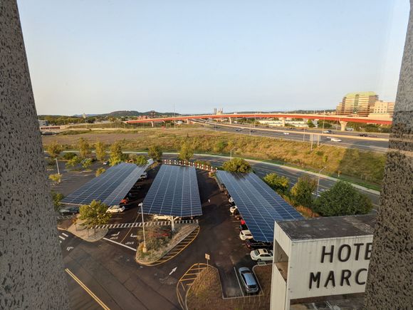 View from NE facing corner, to larger parking lot with solar panel bays and EV charging