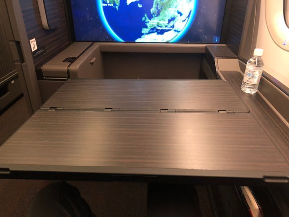 Managed to grab a picture of the tray table before it was rolled back up. There's no worries about it being large enough to hold everything. It's worth noting that I couldn't move it and, as a fairly skinny person, could barely squeeze out between it and the walls of the suite. 