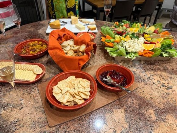 Roasted cherry tomato bruschetta on home made garlic crostini, baguette and crackers, Boursin cheese and jam, fruit and veggie tray with hummus, various cheeses 