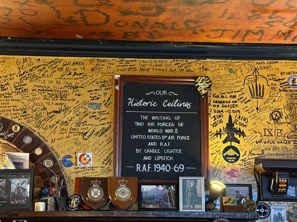 Historic WW2 signatures on the ceiling and modern signatures on the wall at The Eagle
