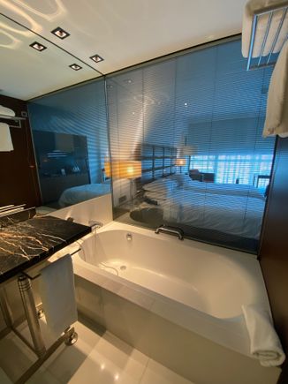 Blinds between the bathroom and bedroom can be closed for privacy.