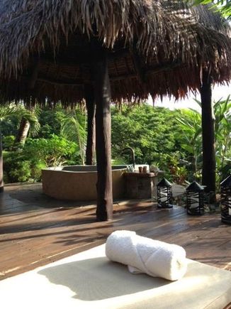 An outdoor relaxation space with bath in a private spa pavilion