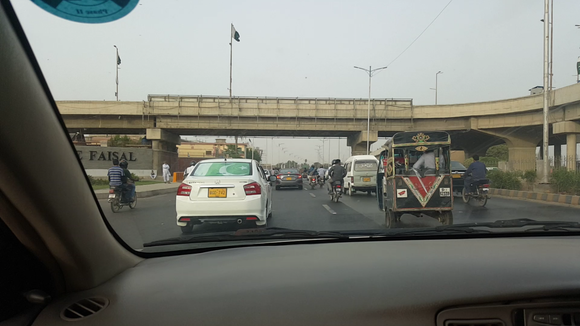 On the way to the Airport. Pakistani Independence Day had just passed (14th Aug), hence national fervor was at it's height. There are 3 flags in this image, can you spot them?
