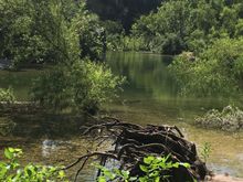 A cliff adjacent a tranquil pool, Greenbelt Trail