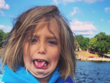 Miss Evie is holding a large minnow in her hand for the first time.