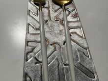 One of many place settings; sleek modern utensils sit atop embossed leather mats; this one was metallic silver; others were deep forest green and other colors..