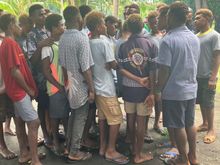 Teens from high school rugby team singing.