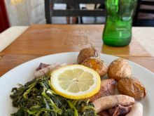 Dinner of grilled squid with potatoes and greens