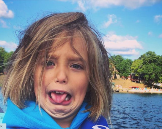 Miss Evie is holding a large minnow in her hand for the first time.