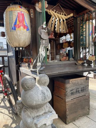 Frog statue beside a frog shrine 