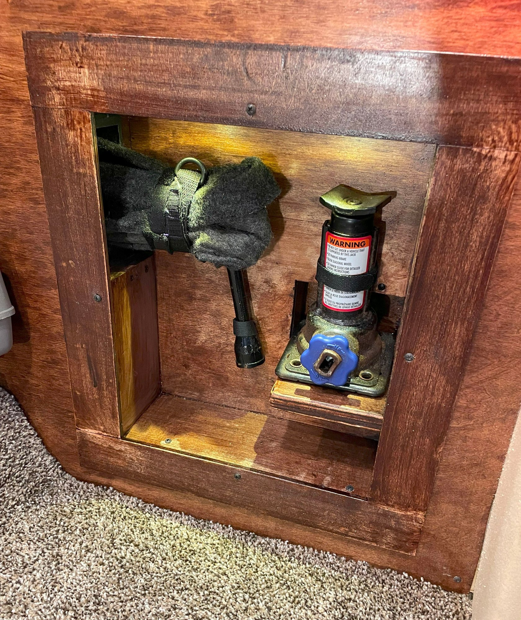 Rear cubby with jack, jack handle, and tire iron