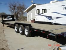 PJ Trailers 36' 'lowboy'. This is a regular 2-car trailer that has a 102&quot; wide deck, slight dovetail for loading rolling stock, and drive-over fenders. The single wheels help reduce deck height for tall freight and the triple axles help spread the weight for better balance.